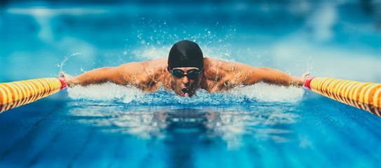 Homme dans la piscine. Façon papillon. Effet mat