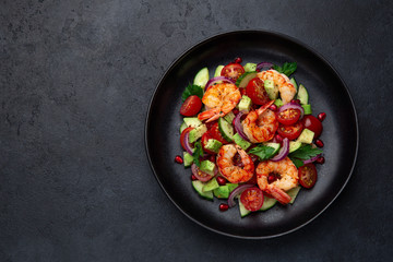 grilled shrimps and vegetable  salad on black plate