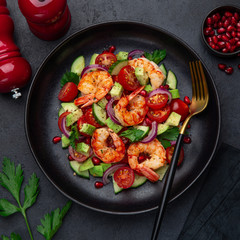 grilled shrimps and vegetable  salad on black plate