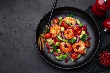 grilled shrimps and vegetable  salad on black plate