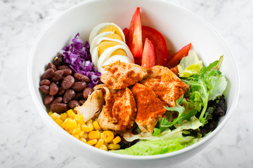 Healthy food concept. Lunch bowl with chicken, egg, tomatoes, lettuce, corn, red beans, red cabbage. Clean food and dieting nutrition concept. Close-up