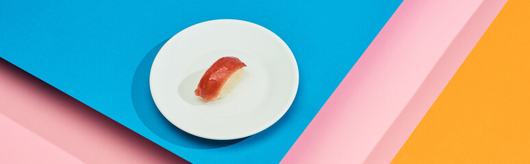 fresh nigiri with tuna on blue, pink, orange background, panoramic shot