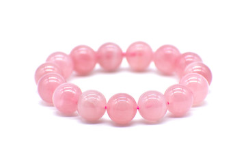 Rose quartz bracelet on white background. The love magnet, unconditional love, forgiveness and...