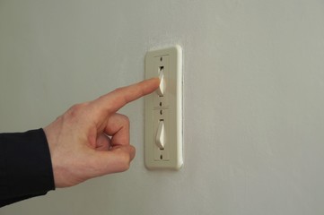 Finger pushing on off button. Top button activated on double switch power button. Switch light on.