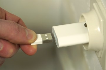 USB cable being plugged in small usb wall charger.