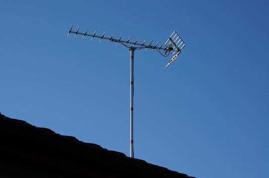 DVB-T tv antenna in residential home. Digital Television TNT antenna in France. Digital Television antenna in Europe on blue sky.