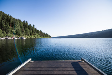 Wooden dock extends over placid mountain lake