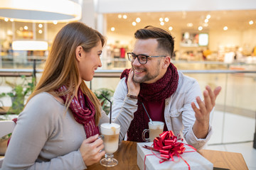 A gentle boyfriend bought a nice little gift for his sweetheart and she is endeared by the thoughtful gesture. She thanks him.