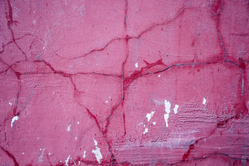 Cracks on a pink wall closeup