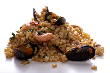fregola sarda con frutti di mare su fondo bianco
