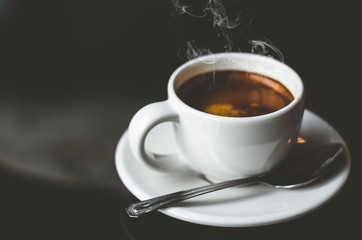 close up coffee on wood table with coffee bubble foam pattern and texture in white cup in dark background looking and feel so delicious on glasses table in coffee shop.