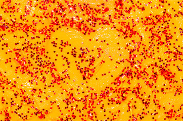 Red heart of spangles on a orange background to the day of Saint Valentine.