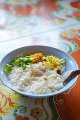 Congee with pork minced and thai celery and deep fried garlic minced.and sliced ginger breakfast or street food in Thailand