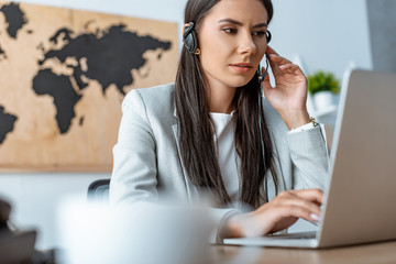 attentive travel agent working near laptop