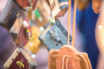 Beautiful blue pocket notebook handmade with a small pencil made of leather hanging among other products.