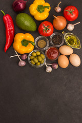 A set of vegetables for a healthy diet, yellow and red peppers, tomatoes, onions, garlic, eggs, olives, rocket,  spinach.  .