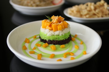 Delicious rice cake with manggo slice and sauce from front view