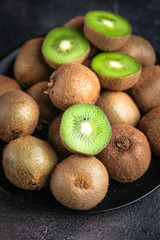 Ripe fresh kiwi fruits  on dark background. Top view with  copy space.