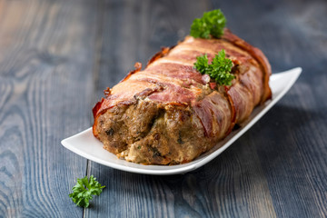 baked roulade of minced meat surrounded by bacon