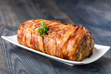 baked roulade of minced meat surrounded by bacon