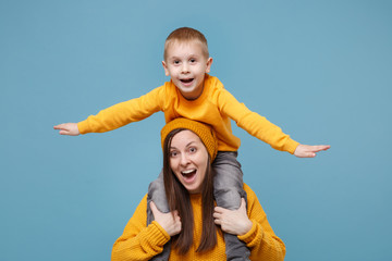 Woman in yellow clothes have fun posing with cute child baby boy 4-5 years old. Mommy little kid son isolated on blue background studio portrait. Mother's Day love family parenthood childhood concept.