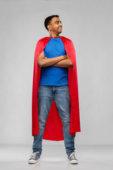 super power and people concept - happy smiling indian man in red superhero cape with crossed arms...