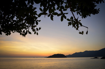 View of seascape in Thailand that have beautiful sunset sky, mountains and trees. Silhouette photo.