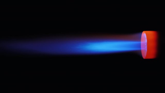 Side view, a nozzle with a jet of blue flame
