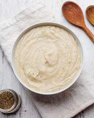 Bechamel. Delicious creamy sauce in bowl on wooden table