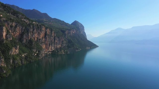 Aerial video with drone.Garda, Italy. In the background a blue sky, rocks in the water. Flight to the drone along the cliff