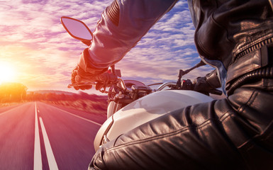 motorcyclist rides on highway direction sun dawn panoramic view rear capture - obrazy, fototapety, plakaty