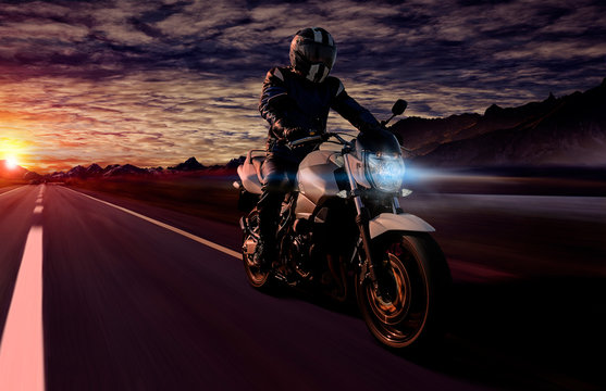 motorcyclist at night riding on highway with motorbike