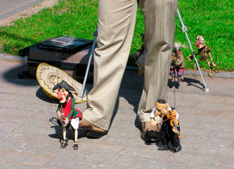Puppet show on the street. Little funny wooden puppets with a guitar and a violin.