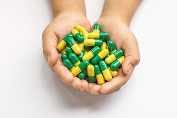 Capsule pills in hand on white background.