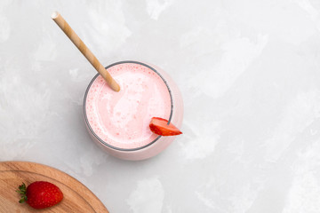 Indian drink Strawberry Lassi in a glass cup with paper straw,