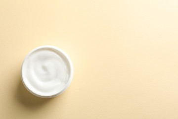 Jar of winter cream for skin on yellow background, space for text. Top view