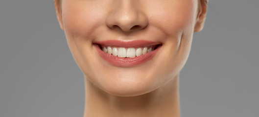 beauty, dental care and teeth whitening concept - close up of beautiful young woman with white...