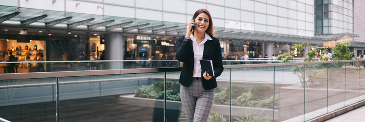 Businesswoman talking on mobile phone in mall