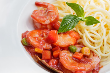 Spaghetti with shrimp sauce in white plate.