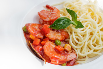 Spaghetti with shrimp sauce in white plate.
