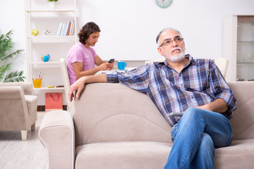 Young student and his old grandpa at home