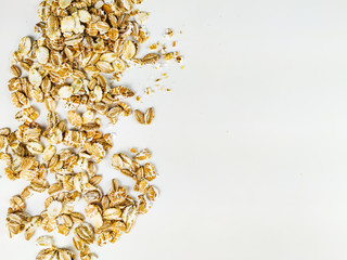 Delicious golden color of oat cereal flakes stacked on one side of the image making an interesting frame of healthy food on white background