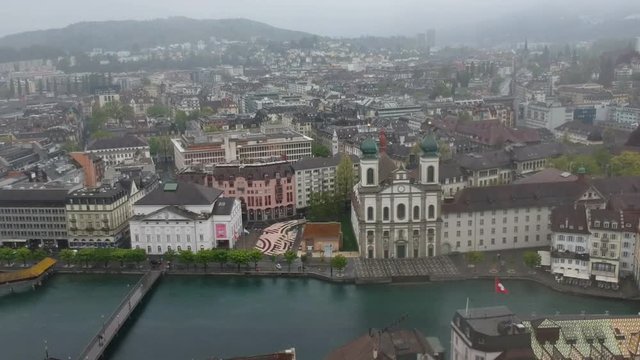 Aerial flyover on a snowy spring day in Luzern, Switzerland, with focus on church