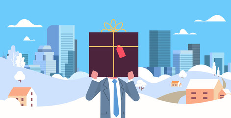 businessman holding gift box in front of face christmas new year winter holidays celebration concept snowfall cityscape background horizontal flat portrait vector illustration