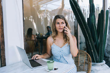 Fototapeta premium Concentrated woman speaking on smartphone at terrace