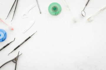 Dental care concept. Stomatological tools frame - with floss - on white background top-down frame space for text