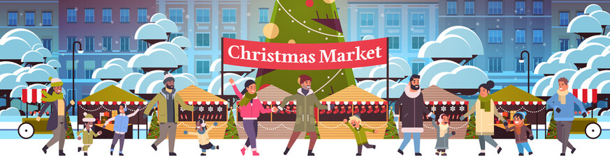 Obraz premium christmas market or holiday outdoor fair with decorated fir tree mix race people walking near stalls merry xmas new year winter holidays celebration concept modern cityscape background horizontal