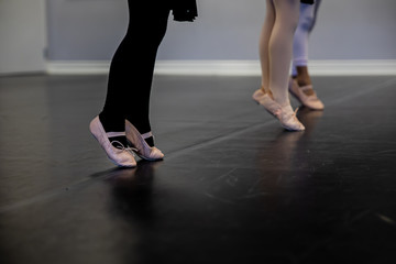 Fototapeta na wymiar Young children stand on tip toes in ballet class