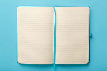 Open notebook, a book with blank and blank pages on a blue background, top view.