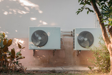 air conditioner compressor outdoor unit installed outside the house.